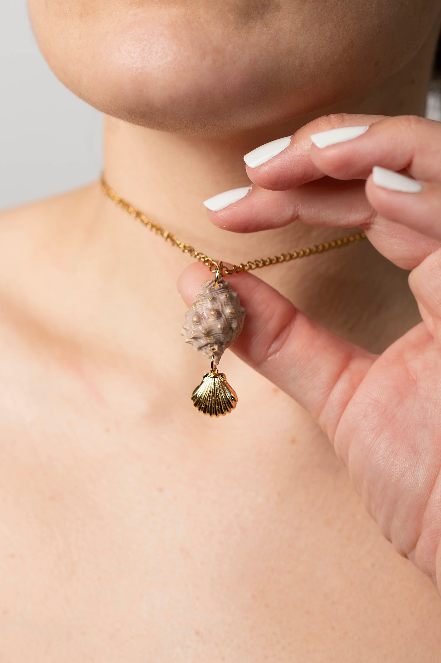 Colgante caracola rosada con tonos dorados