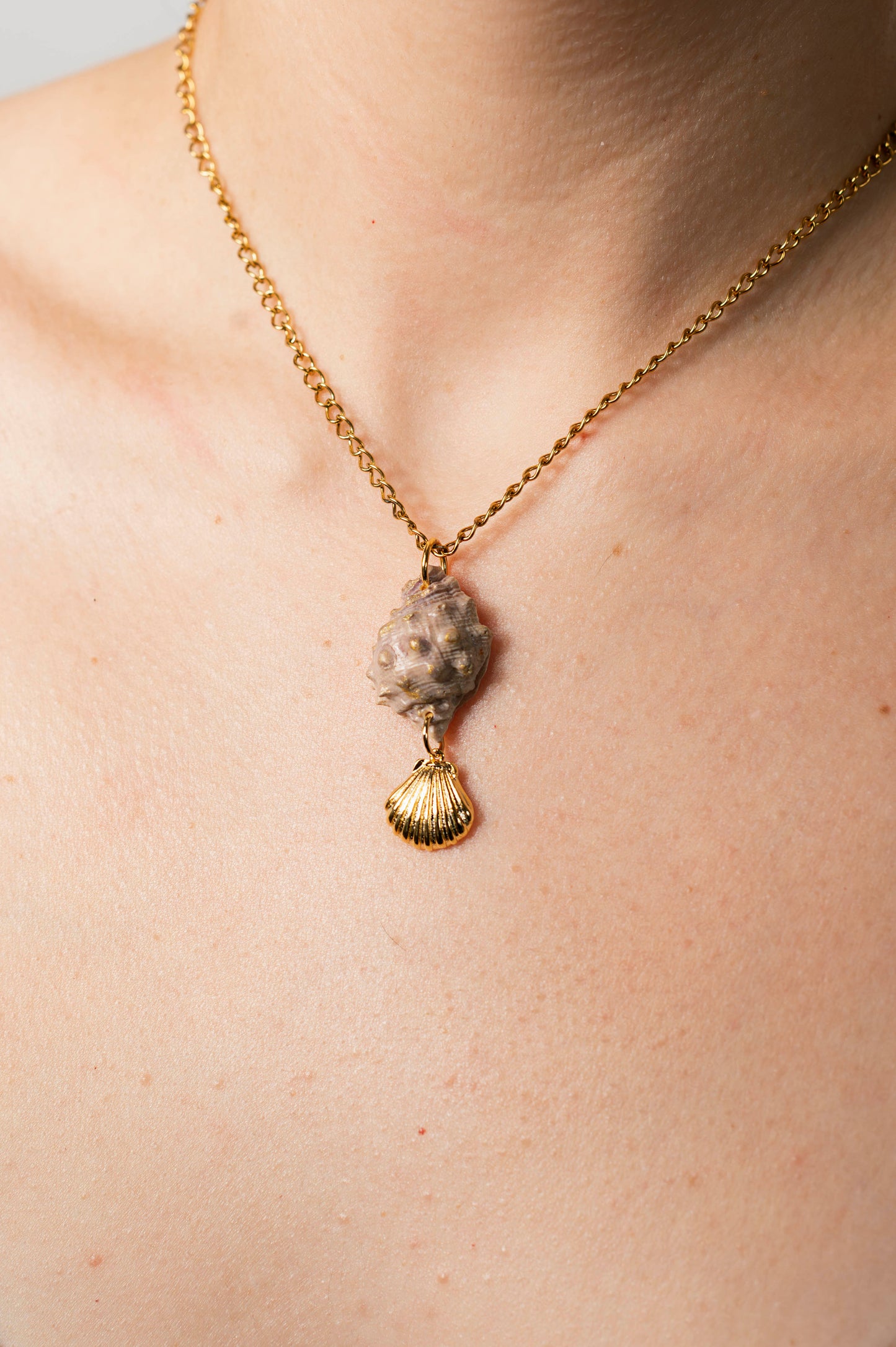 Colgante caracola rosada con tonos dorados