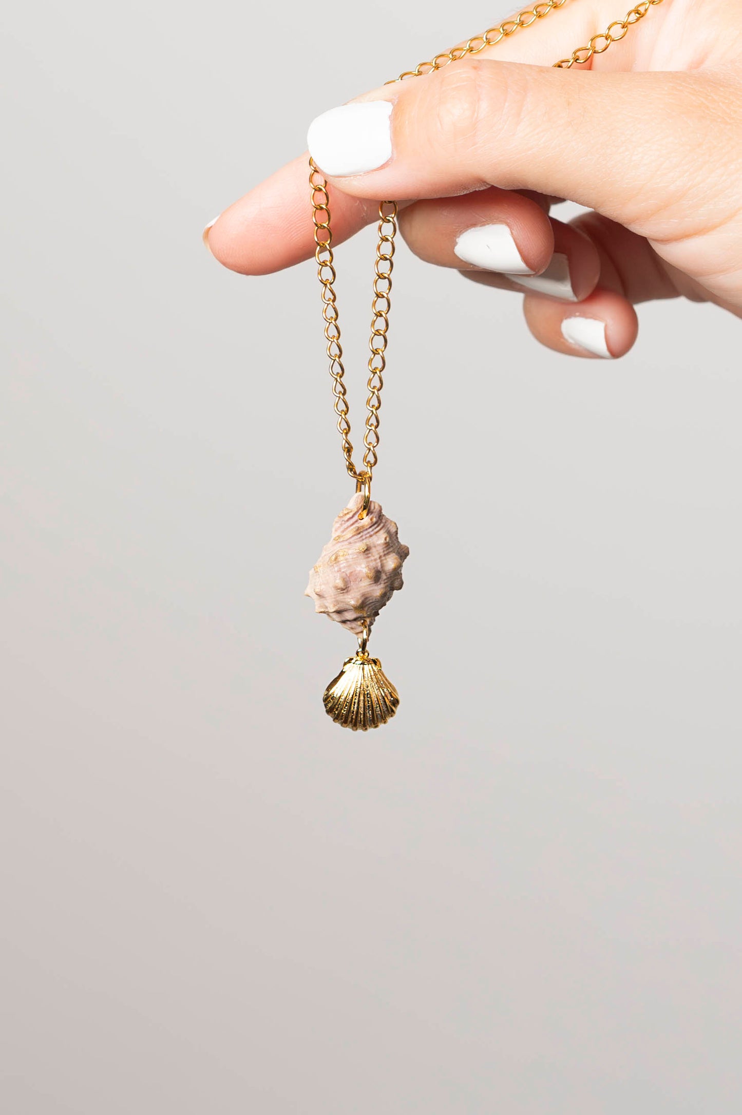 Colgante caracola rosada con tonos dorados